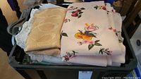 Folded mixed linens showing floral print and beige patterned fabric