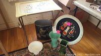 View of all items in lot: decorative round tray, vintage TV tray, 4 vases and metal waste bin.