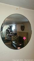 Large round mirror approximately 30 inches in diameter, showing etched bird design and surrounding leaves etched into glass with a textured element, mounted on wall.