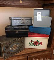 Overview photo of all 6 tins and boxes stacked on each other showing size and condition