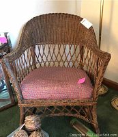 Full view of the wicker rocking chair with cushion placed on seat, showing overall shape and construction.