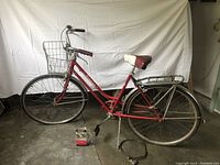 Side profile of the complete red Schwinn Breeze women's bicycle showing its step-through frame, metal front basket, rear rack, and tires.