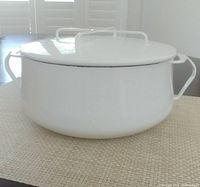 Full side view of white enamel Dutch oven with lid in place.
