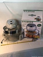 Full view of Big Boss Oil-Less Fryer with the original box behind it and a measuring tape showing size.