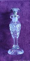 Birks vintage perfume bottle showing cut crystal clear glass with intricate designs and detailed pedestal base.