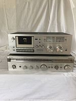 Front view of ProSonic cassette deck on top of Hitachi stereo receiver showing controls and display.