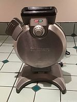 Front view of Cuisinart vertical waffle maker showing stainless steel housing and control dial.