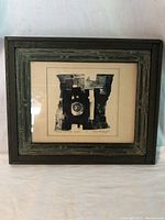 Framed black and white abstract art print in distressed wooden frame.