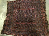 Full view of one side of the vintage reversible oriental rug showcasing geometric patterns and wear.