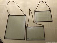 Three vintage glass and copper hanging frames displayed on a surface, showing size and hanging chains.