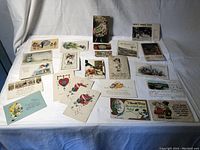 Group view of the vintage postcards spread out showing a variety of illustrated designs including floral, seasonal, and children themes.