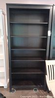 Full view of the dark brown wooden bookcase showing five shelves and overall structure.