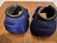 Pair of blue durables caddy horse hoof protectors with padded collars shown from the back.