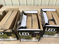 Three open boxes showing LED string lights partially inside with packaging materials