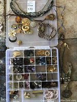Overhead view of all jewelry laid out in plastic organizer tray and surrounding pieces