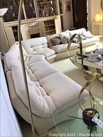 Full view of sectional arranged in living room showing all three sections, tufted back cushions and integrated seats