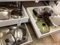 Overview of two drawers filled with Copper Ware cookware items including pots, pans, lids, and a griddle.
