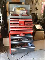 Front view of closed two-part red and silver metal Craftsman tool cabinet on casters