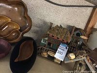 Photo showing wooden decorative houses and several wooden serving bowls with unique shapes.