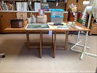 Front view of the solid wood dining table with two folding leaves extended, placed in a room with items on top.