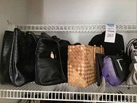 Shelf view showing multiple black handbags and woven handbag with bamboo handles, some purple and color mixed bags