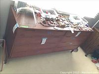 Front view of dresser with six drawers and items on top.