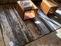 Top view of the modern blue and brown area rug with two wooden cube-shaped stools on it, showing the texture and pattern.