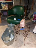 Group photo showing the green leather and wood desk chair, cast iron plant stand holding large rose quartz, aluminum tub and flower bucket arranged on basement floor.