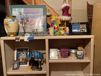 Wide shot of shelf with vases, picture frames, and decorative items