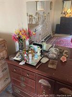 Wide shot of vanity table with various decorative items, flowers, and mirrors