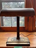 Front view of brass desk lamp showing shade, column and base