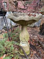 Front view of assembled birdbath against brick backdrop