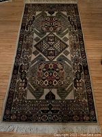 Full view of Persian wool carpet runner laid on hardwood floor, showing overall geometric pattern and fringed end