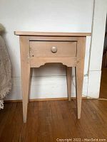 Front view of the pine end table showing single drawer and tapered legs.