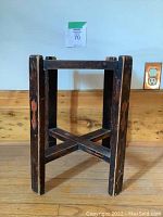 Front view of square wood table showing four legs and cross stretcher.