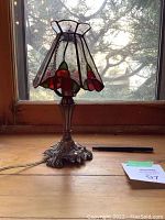 Front view of lamp on wooden surface in front of window