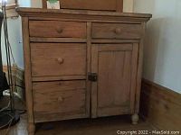 Front view of narrow pine cabinet showing two small top drawers, two larger left drawers, and right door