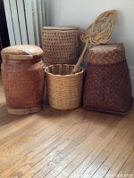 Front view of four baskets and carpet beater arranged on hardwood floor
