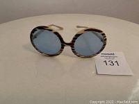 Front view of the vintage round sunglasses showing the blue lenses and tortoiseshell frame pattern.