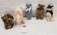Five plush animals lined up showing the full group including various species and colors