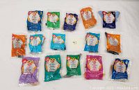 Full set of 15 McDonald's Ty Beanie Babies Happy Meal toys in original sealed packaging displayed on flat surface.