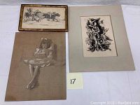 Three framed drawings displayed on a white surface. One shows two polo players riding horses, another a sepia portrait of a young girl reading, and a third a dark abstract drawing of a woman with a tree and crescent moon.