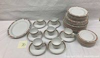 Full view of the Leonard Paris china set including cups, saucers, platter, and plates stacked in piles
