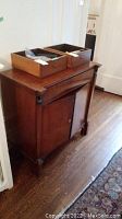 Frontal view of wood cabinet with two removable drawers placed on top