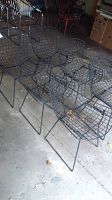 Six black wire chairs arranged in two rows