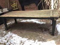 Front-left angled view of wooden table on brick patio