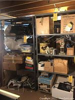 Front view of two black metal shelving units loaded with various boxes and items in storage.