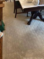 Ivory area rug under dining table showing overall size and condition