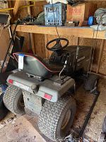 Rear view of tractor showing seat, rear tires and Craftsman branding
