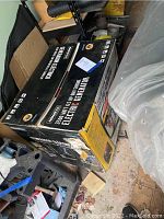Boxed Nikota electric generator with label showing 3500 watt, 6.5 HP OHV engine specifications in the cluttered garage.